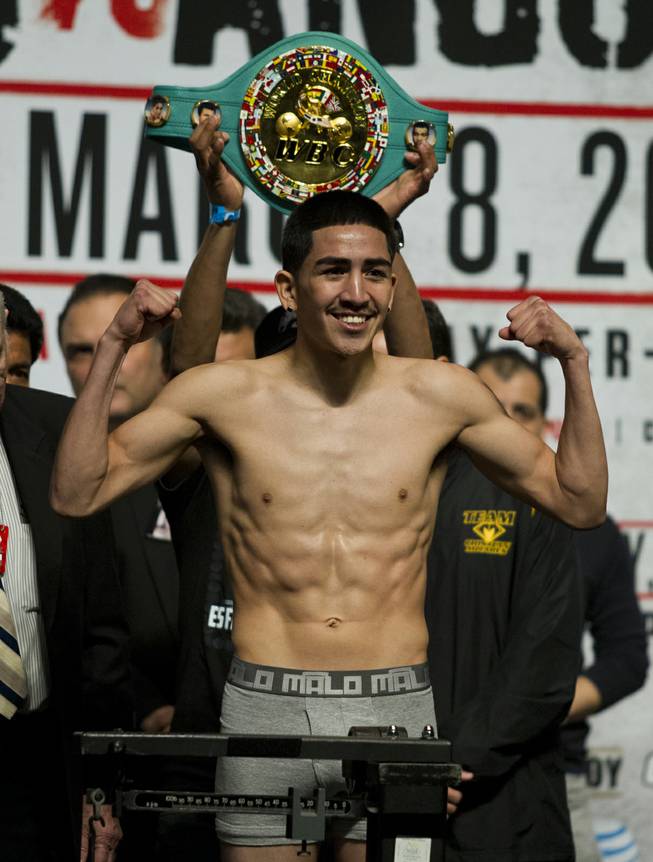 WBC Super Bantamweight Leo Santa Cruz of Mexico poses for the crowd while on the scale during his weigh-in at the MGM Grand Arena on Friday, March 07, 2014.